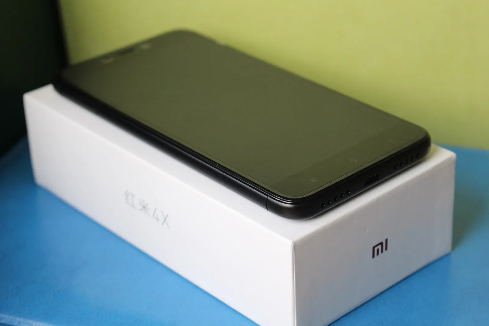 A black Redmi 4X lying on its white Mi box
